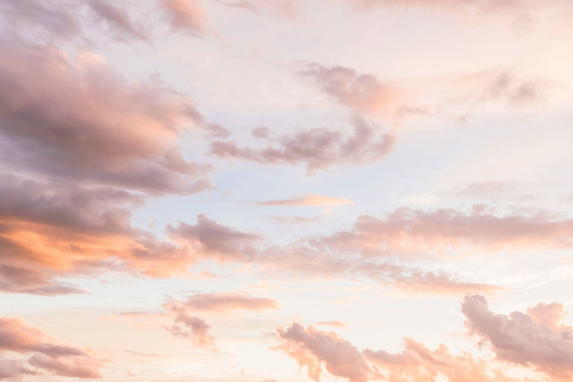 Pastel-colored sky with scattered clouds during sunset or sunrise.